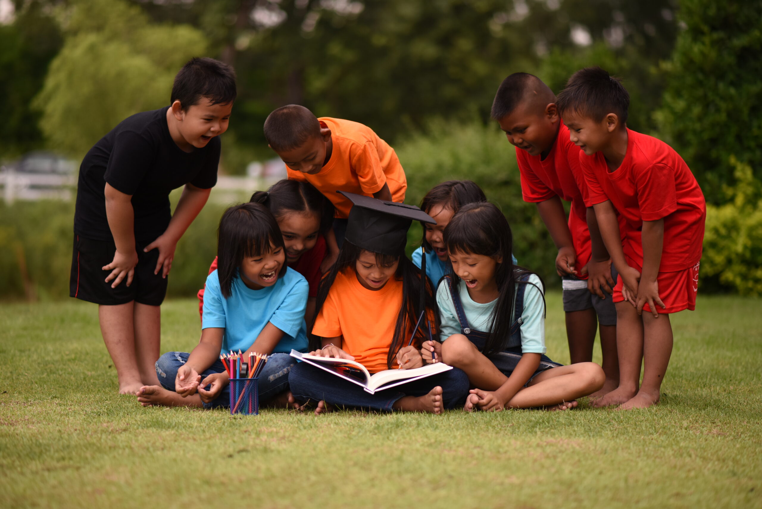group children lying reading grass field scaled