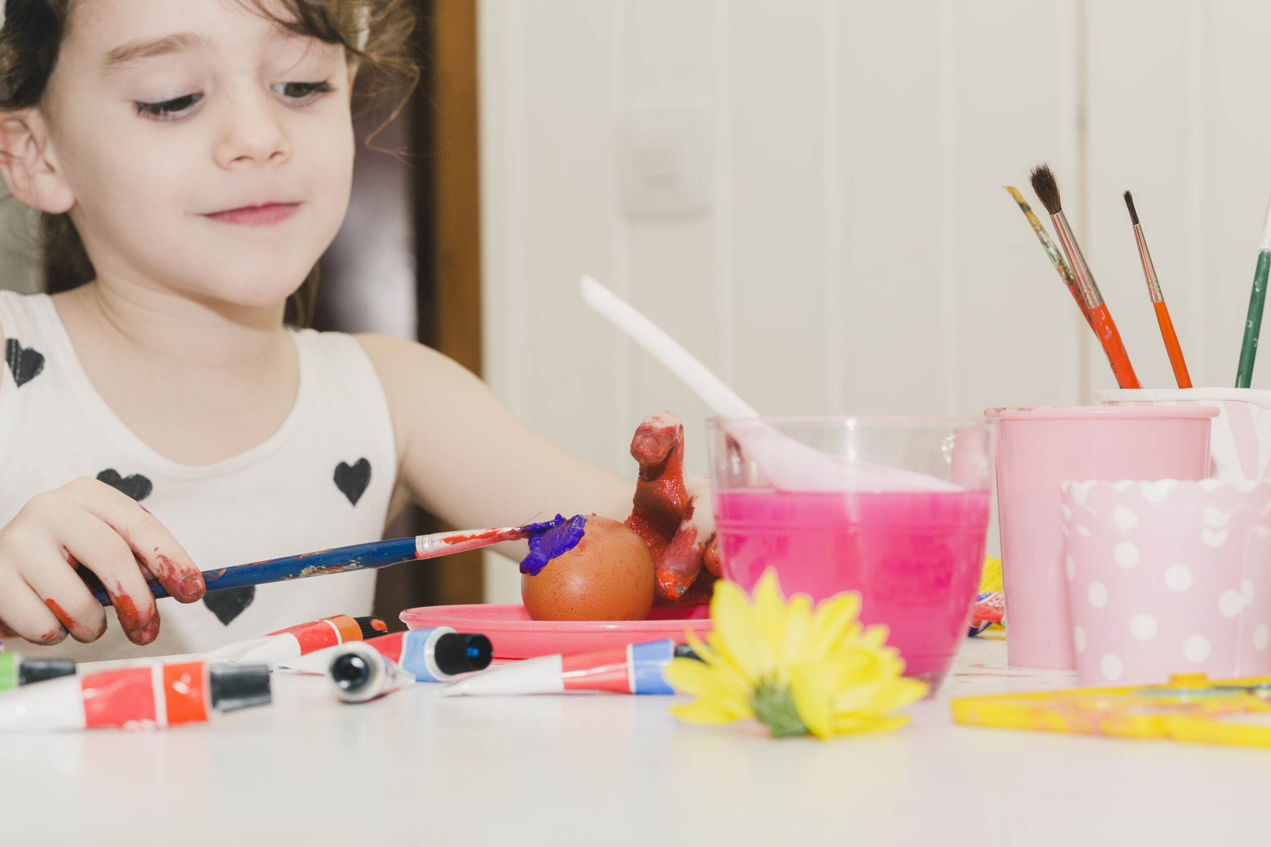 The Importance of Creative Activities in Early Childhood | Preschool in Wakad Pune 1 lovely girl painting egg with violet scaled