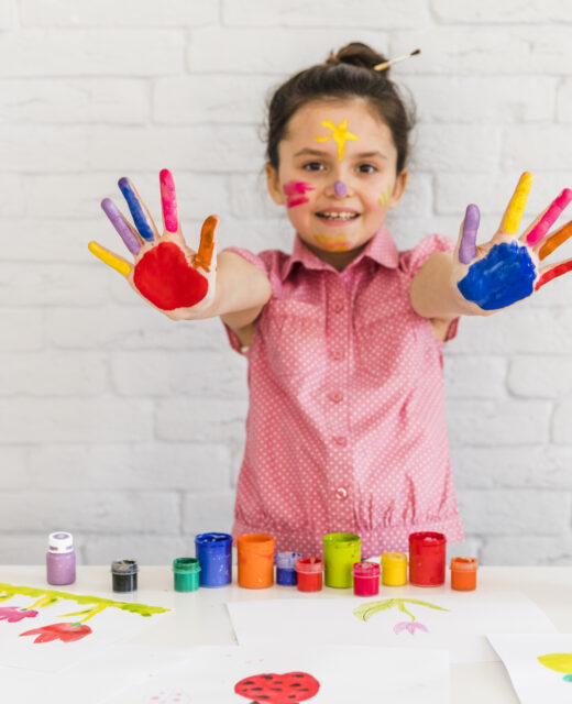 smiling portrait girl showing her painted colorful hand camera